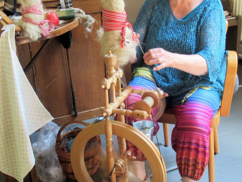 Spinners and weaver working on spinning wheels making yarn at the Shetland  Wool Week Stock Photo - Alamy