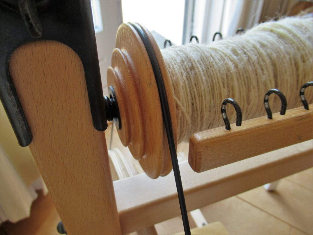 Spinners and weaver working on spinning wheels making yarn at the Shetland  Wool Week Stock Photo - Alamy